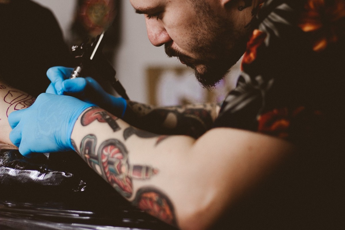Egy tetoválóművész dolgozik.