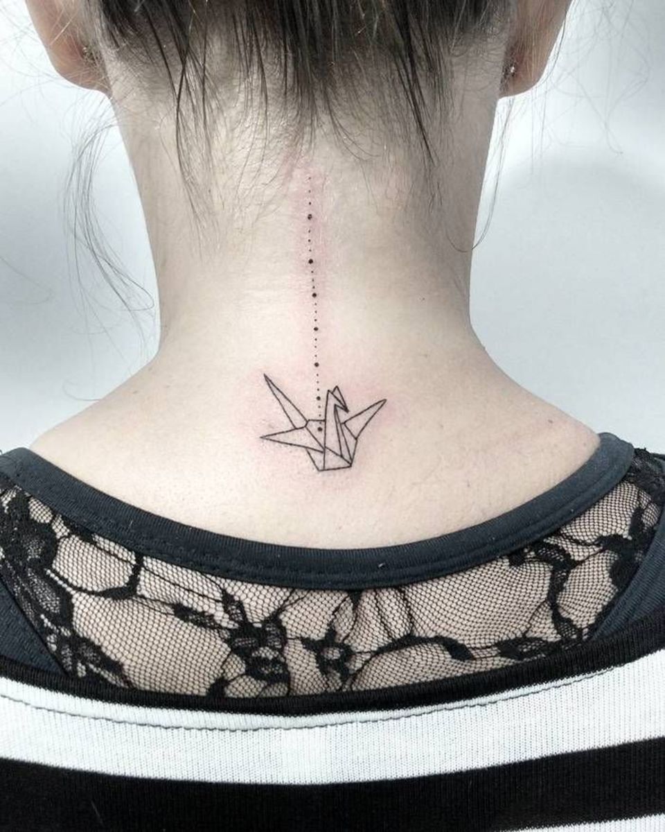 En tatovering av en origami -kran på baksiden av nakken.