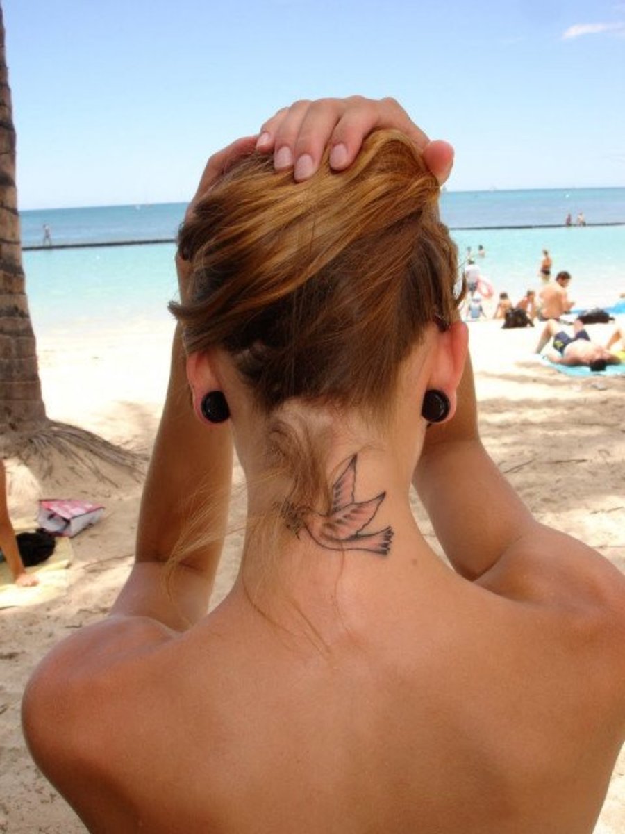 Nő egy galamb tetoválással a nyakán