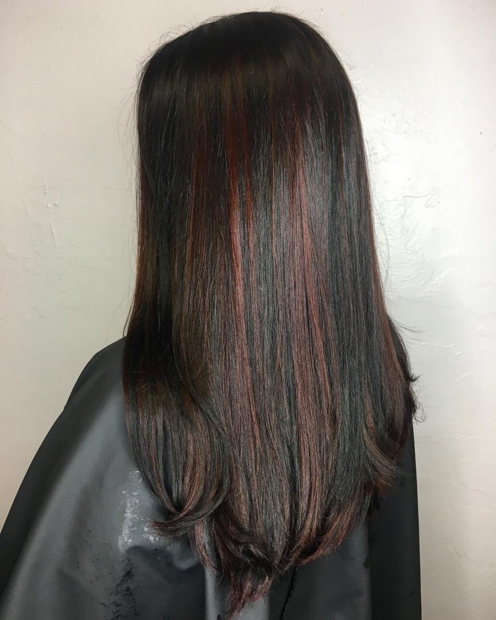 Tummanpunaiset Peekaboo -kohokohdat tummissa hiuksissa