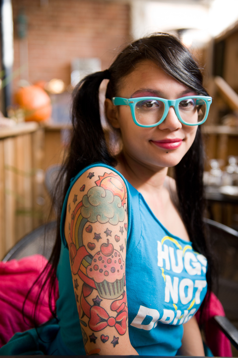 En kvinne med en fargerik cupcake -tatovering.