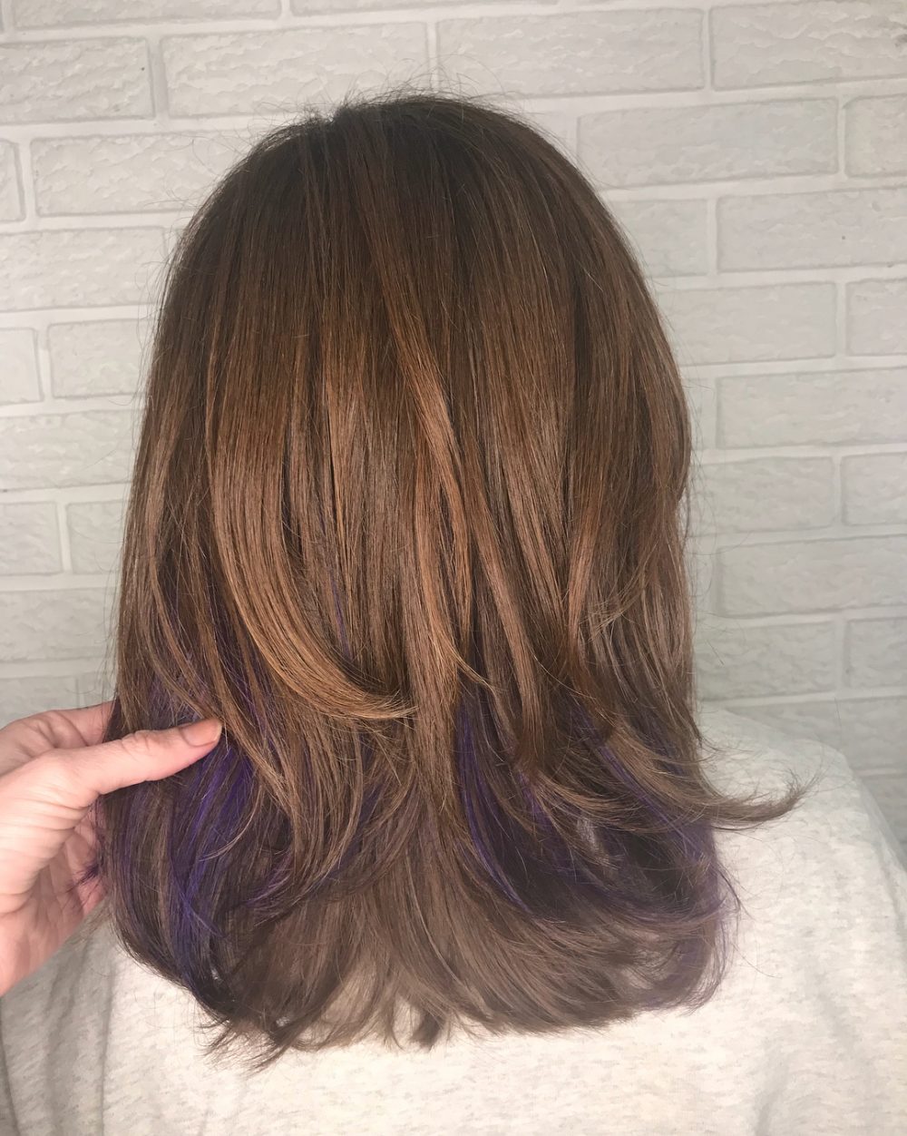 Tumman violetit Peekaboo -kohokohdat keskikokoisissa ruskeissa hiuksissa