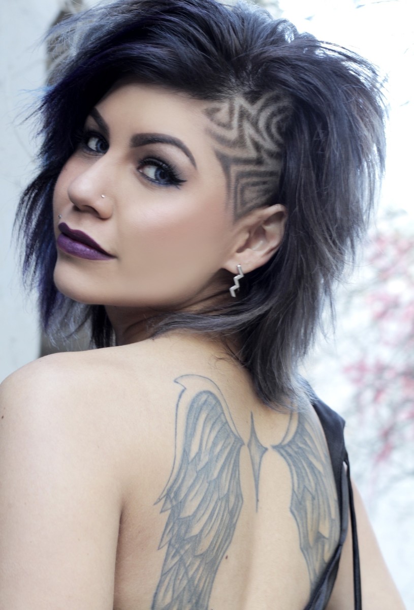 Nainen, jolla on kaksi tatuoitua siipeä, yksi lapaluuta kohden.