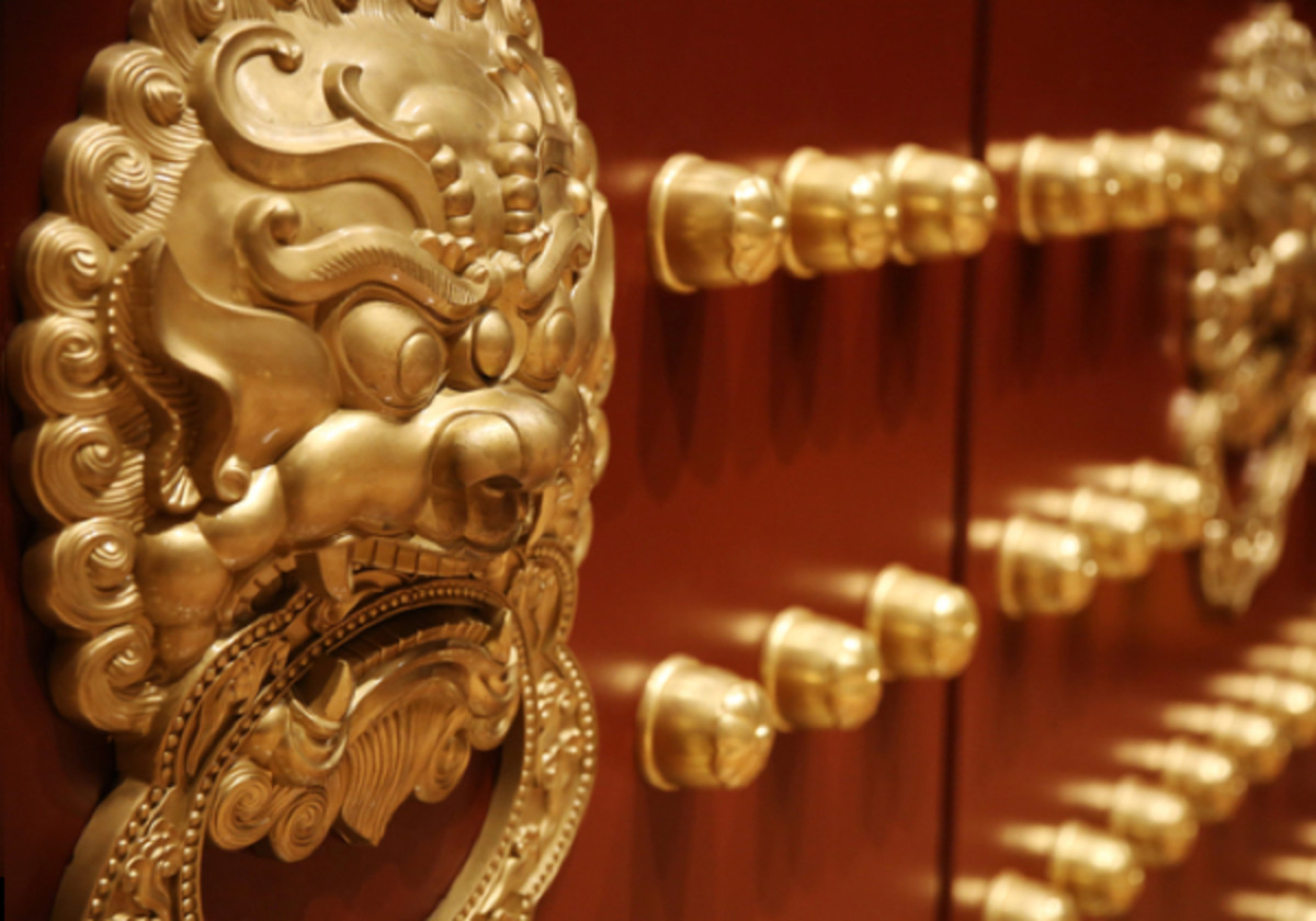 Bronzový klepadlo na hlavu čínského lva na tradičních dřevěných dveřích.